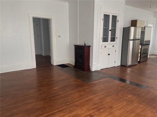 empty room featuring dark wood-type flooring and ornamental molding