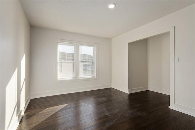 unfurnished room with dark wood-type flooring