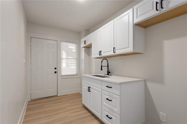 kitchen featuring white cabinets, sink, and light hardwood / wood-style flooring