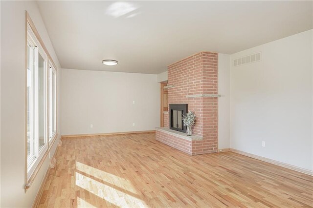 unfurnished living room with a fireplace and light hardwood / wood-style flooring