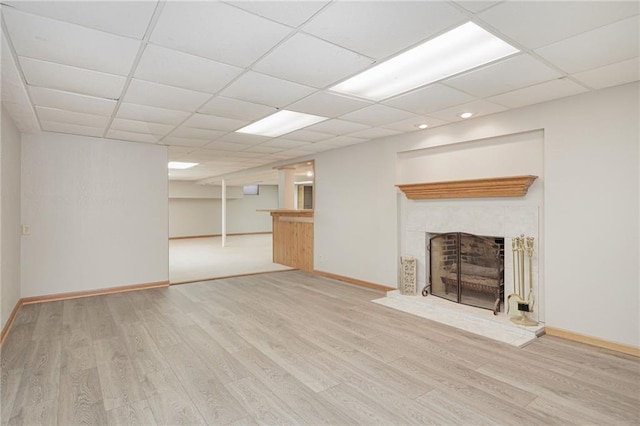 unfurnished living room with a drop ceiling and light hardwood / wood-style floors