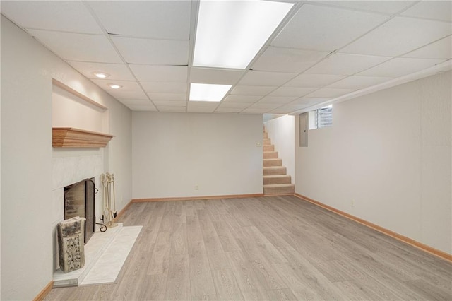 basement featuring light hardwood / wood-style flooring and a paneled ceiling