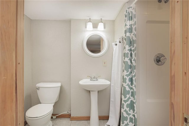 bathroom featuring toilet, a shower with shower curtain, and tile patterned floors