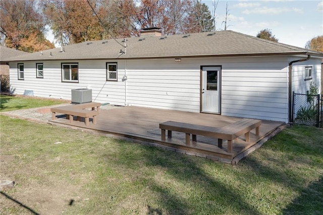 rear view of property featuring a lawn, a wooden deck, and cooling unit