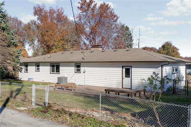 rear view of house with central AC and a yard