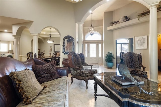 living room with light tile patterned floors, a high ceiling, and an inviting chandelier