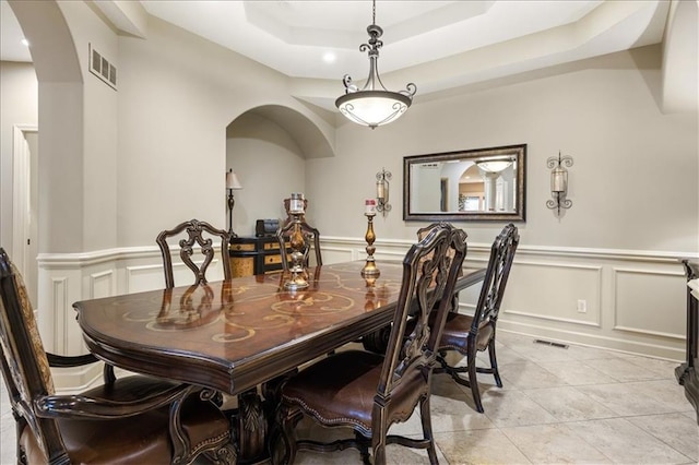 tiled dining area featuring a tray ceiling