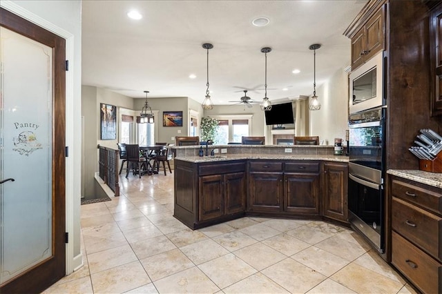 kitchen with appliances with stainless steel finishes, hanging light fixtures, a healthy amount of sunlight, and ceiling fan