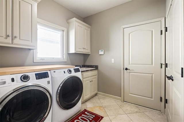 clothes washing area featuring sink, cabinets, washing machine and clothes dryer, and light tile patterned flooring