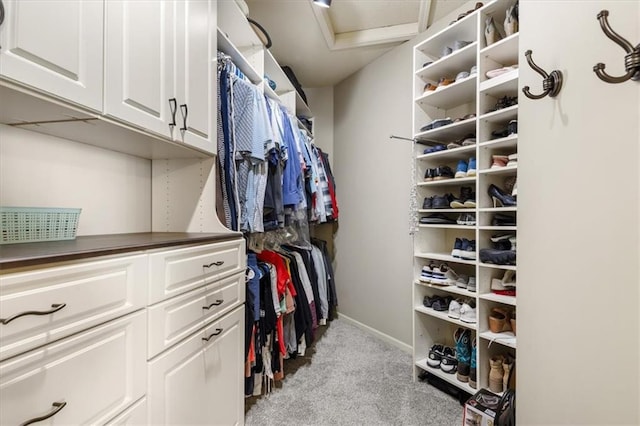 walk in closet featuring light carpet