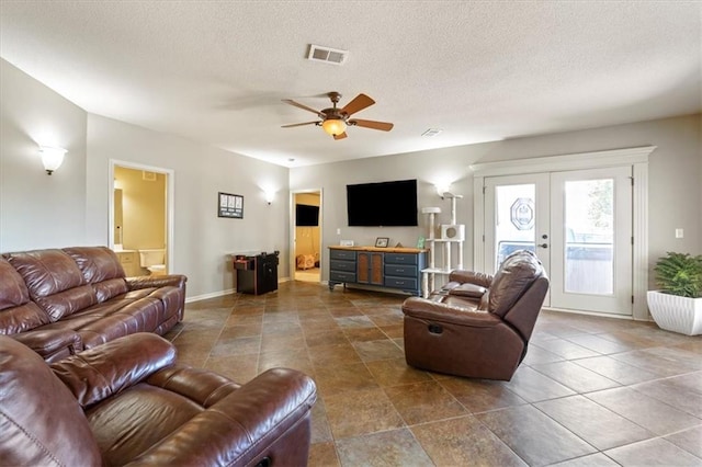 living room with ceiling fan, a textured ceiling, and french doors