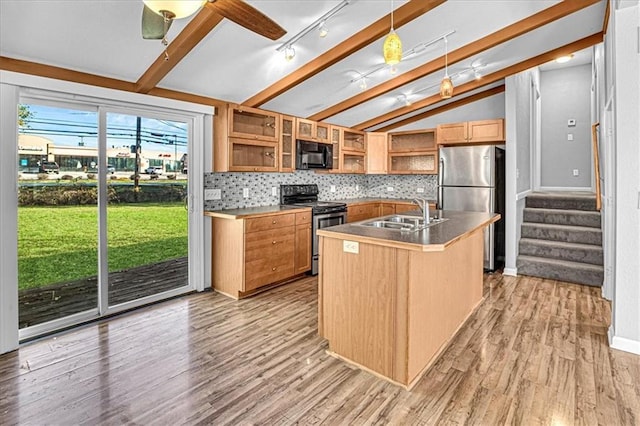 kitchen featuring stainless steel appliances, sink, light hardwood / wood-style flooring, lofted ceiling, and an island with sink