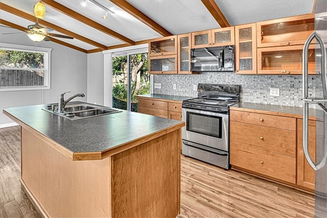 kitchen featuring stainless steel appliances, sink, lofted ceiling with beams, a center island with sink, and light hardwood / wood-style floors