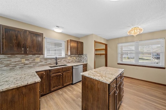 kitchen featuring a wealth of natural light, light hardwood / wood-style floors, sink, and dishwasher