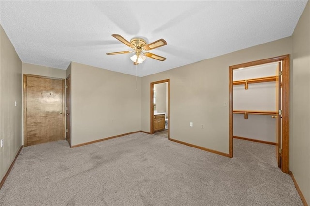 unfurnished bedroom with light colored carpet, ceiling fan, a spacious closet, and a closet