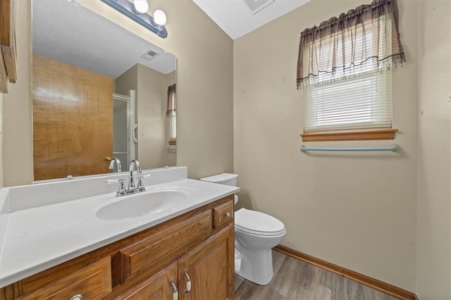 bathroom with hardwood / wood-style floors, vanity, and toilet