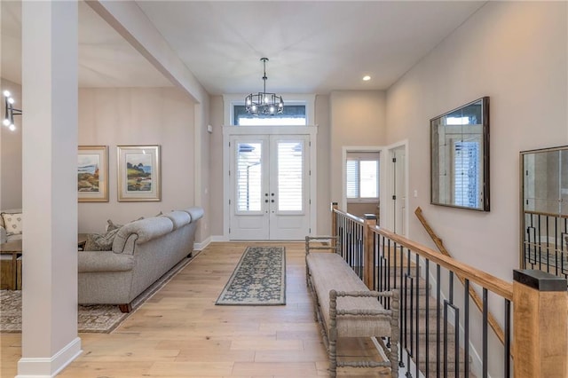 foyer featuring a chandelier, french doors, and light hardwood / wood-style flooring