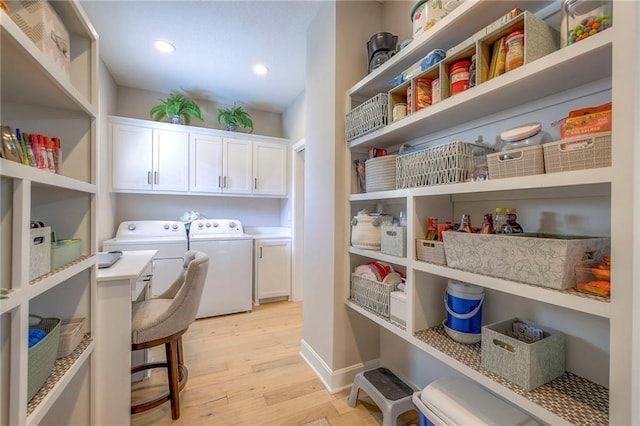 laundry room featuring light wood-type flooring, cabinets, and independent washer and dryer