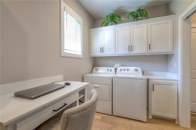 laundry area with cabinets, washer and dryer, and light hardwood / wood-style flooring