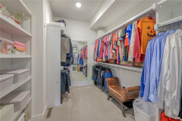 walk in closet featuring light colored carpet