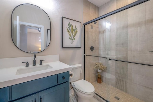 bathroom with vanity, toilet, and a shower with door