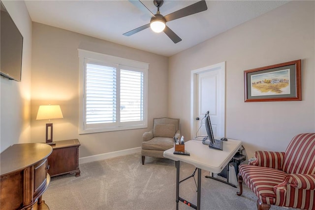 carpeted office space featuring ceiling fan