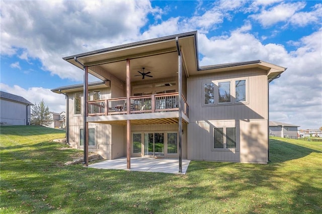 rear view of house featuring a balcony, ceiling fan, a yard, and a patio area