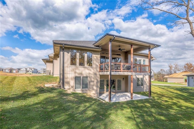 rear view of property with a lawn, ceiling fan, a patio, and a balcony