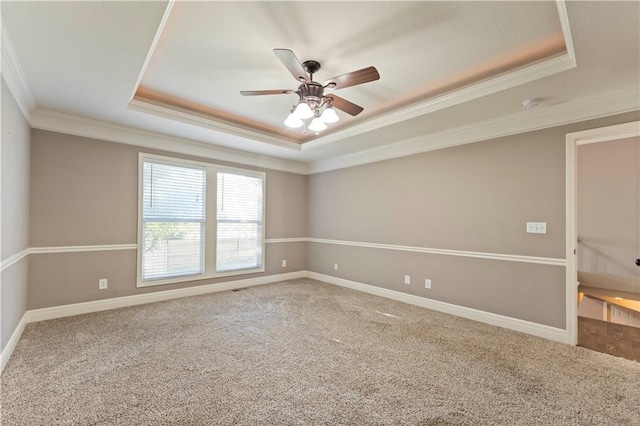 carpeted spare room featuring ornamental molding, ceiling fan, and a tray ceiling