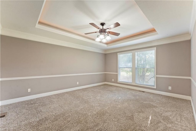 unfurnished room featuring a tray ceiling, crown molding, and carpet floors