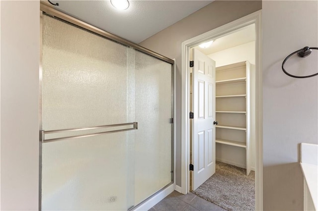 bathroom featuring tile patterned flooring and an enclosed shower