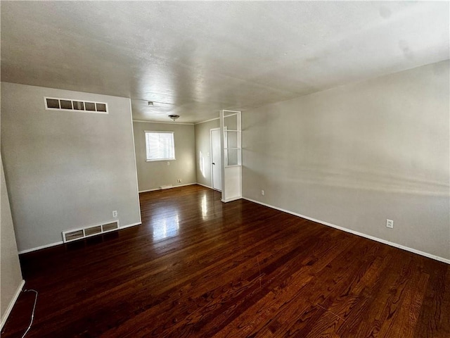 unfurnished room with dark hardwood / wood-style flooring