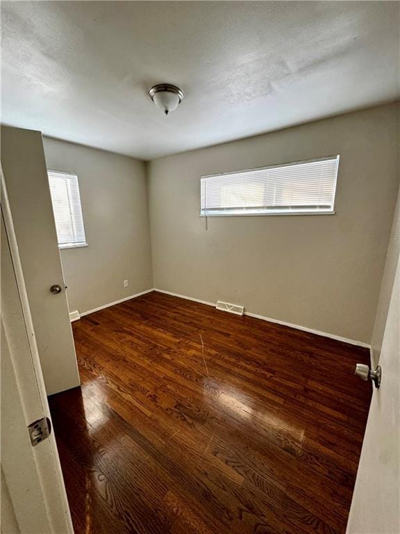 unfurnished room with dark hardwood / wood-style floors