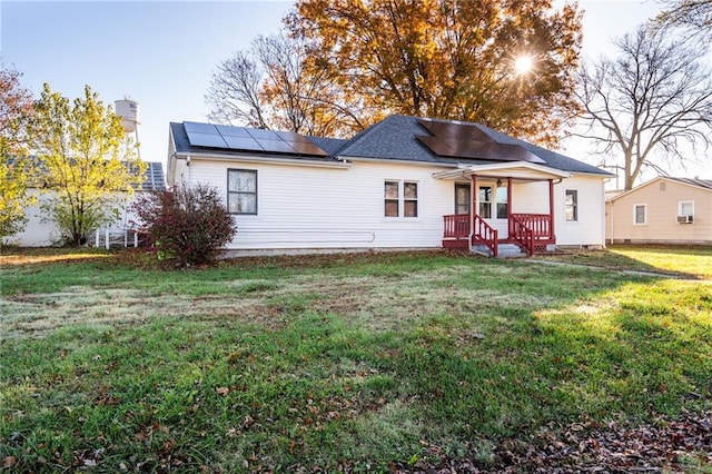 view of front of home featuring a front lawn and solar panels