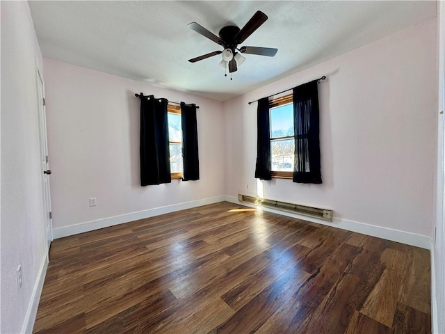 unfurnished room with a wealth of natural light, a baseboard radiator, and dark wood-style flooring