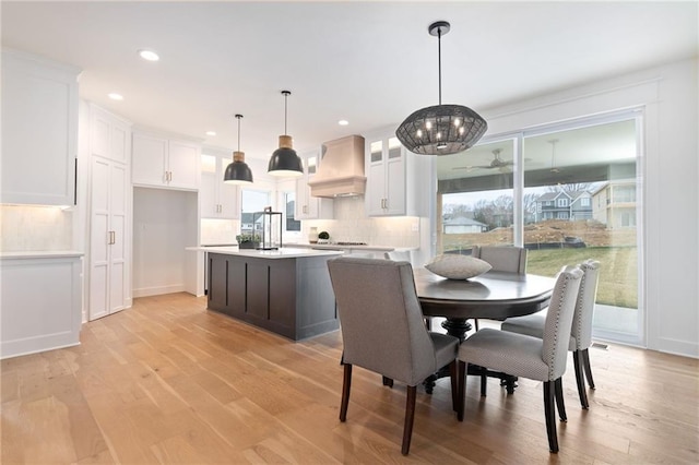 dining area with a chandelier, plenty of natural light, and light hardwood / wood-style flooring