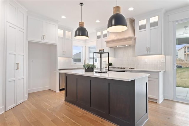 kitchen featuring an island with sink, light hardwood / wood-style floors, and white cabinetry