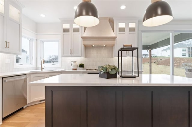 kitchen featuring dishwasher, pendant lighting, sink, and white cabinets