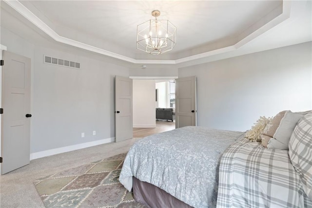 bedroom featuring a tray ceiling, carpet, and a chandelier