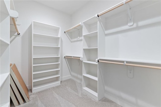 walk in closet featuring light colored carpet