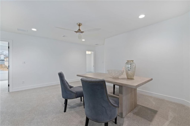 dining space featuring light colored carpet and ceiling fan