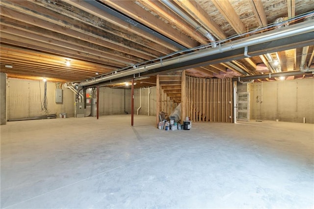 basement featuring electric panel and water heater