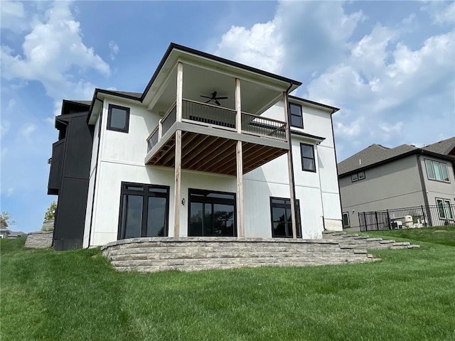 back of property with a lawn, ceiling fan, and a balcony