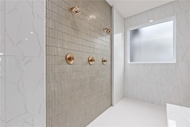 bathroom featuring tile walls and a tile shower