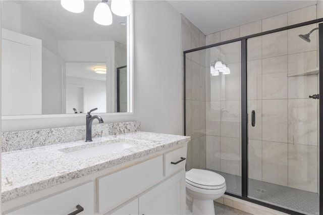 bathroom with toilet, an enclosed shower, and vanity