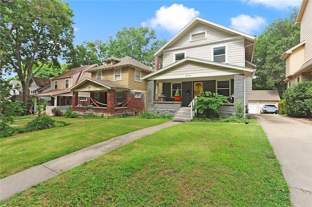 6206 Harrison St, Kansas City, MO 64110 - traditional style home featuring a porch, a front lawn, and a garage