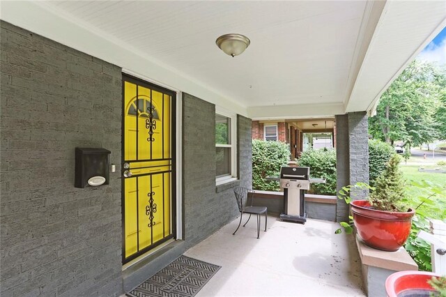 6206 Harrison St, Kansas City, MO 64110 - view of exterior entry with a porch and brick siding