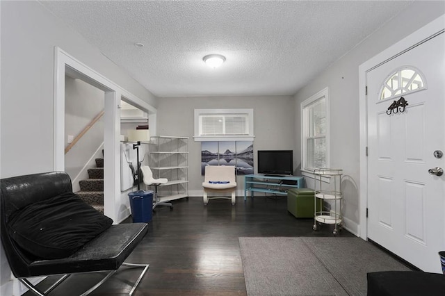 foyer entrance with dark wood-type flooring and a textured ceiling