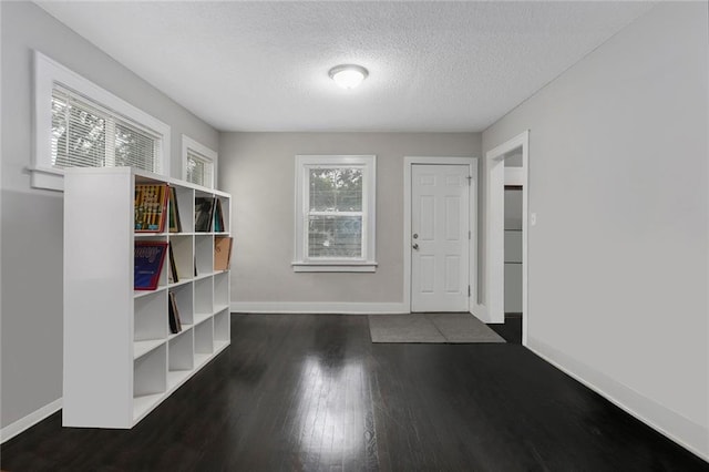 interior space with dark wood-type flooring and a textured ceiling