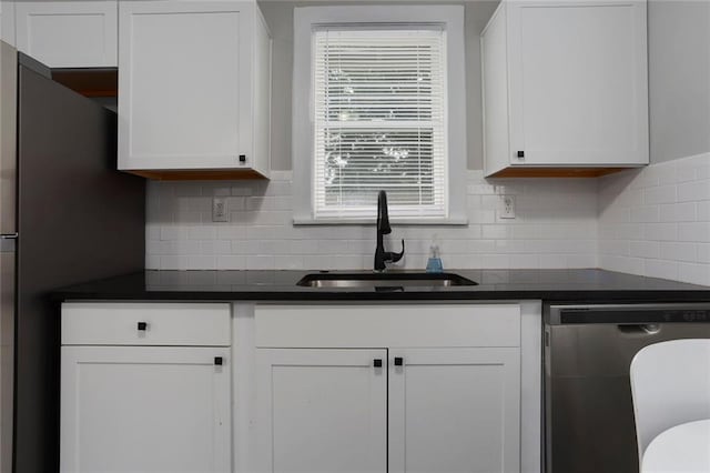 kitchen featuring white cabinets, tasteful backsplash, sink, and dishwasher